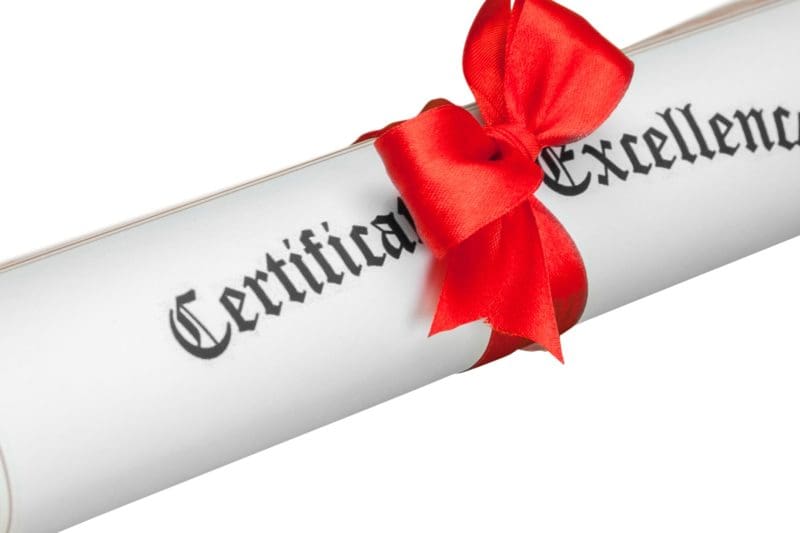 Rolled certificate with red ribbon labeled Certificate of Excellence.