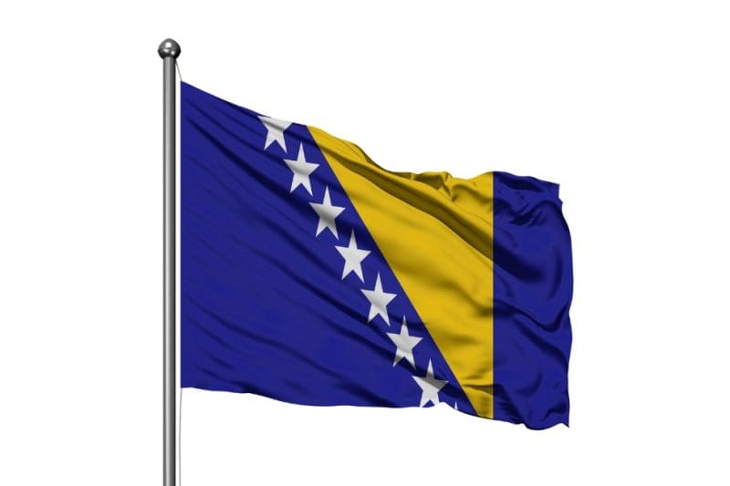 Flag of Bosnia and Herzegovina waving on a pole.