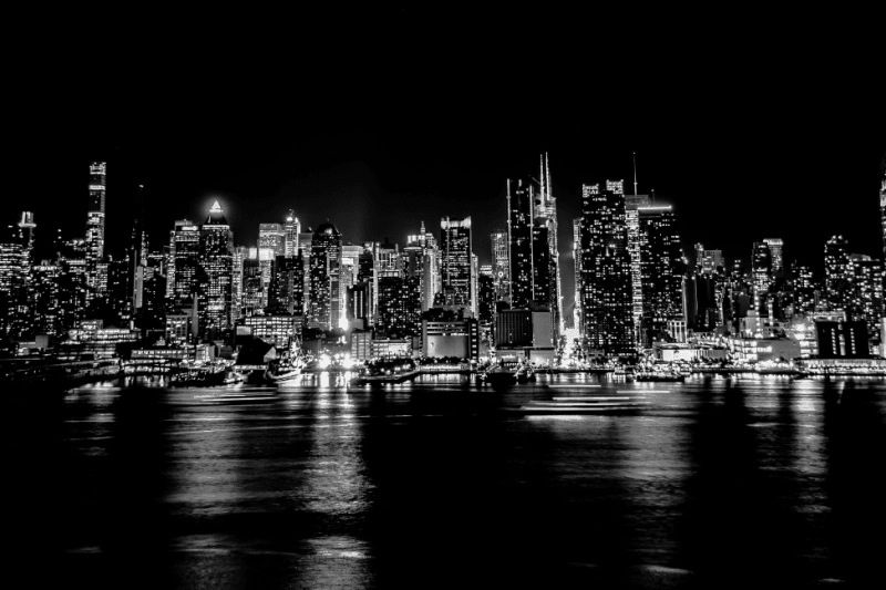 New York City skyline at night with illuminated buildings.