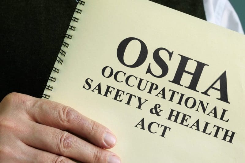 OSHA booklet held for workplace safety guidelines.