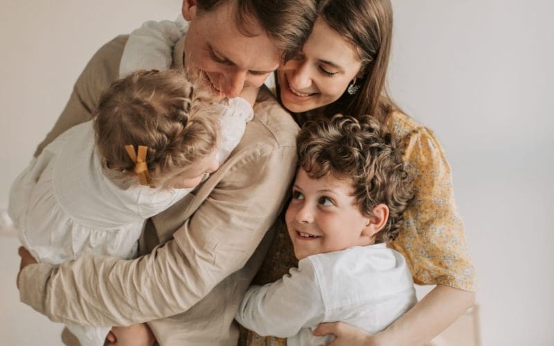Family embracing with smiles, creating a warm, loving moment.