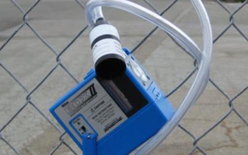 Gas monitoring device attached to a chain-link fence.