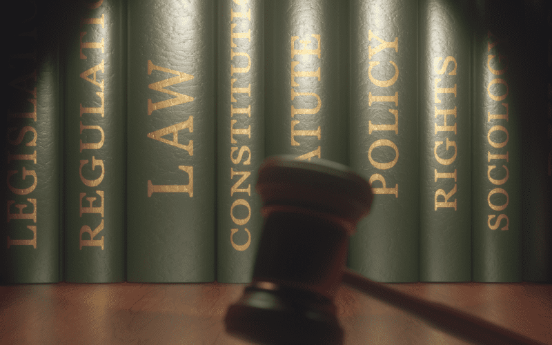 Legal books with a gavel in soft focus in front.