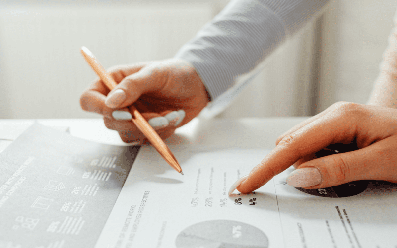 Hands reviewing a financial report with graphs and data.