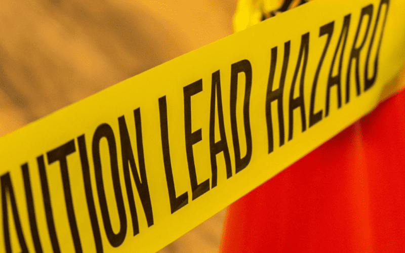 Yellow caution tape with text warning of lead hazard.