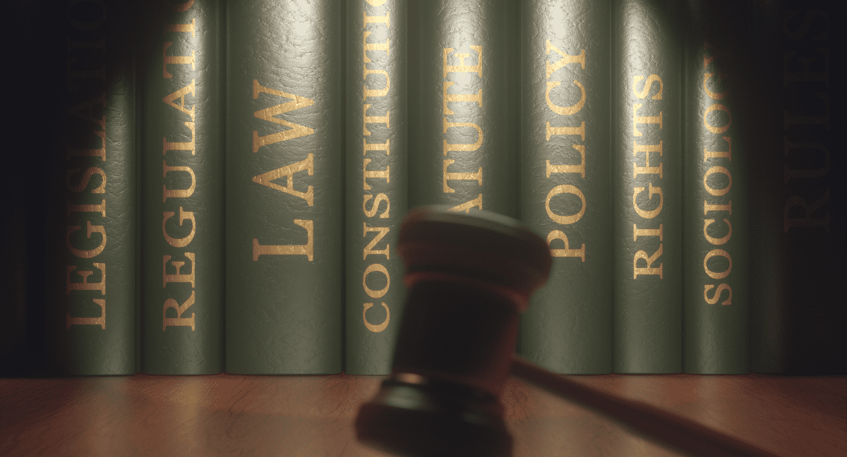 Legal books with a gavel in soft focus in front.