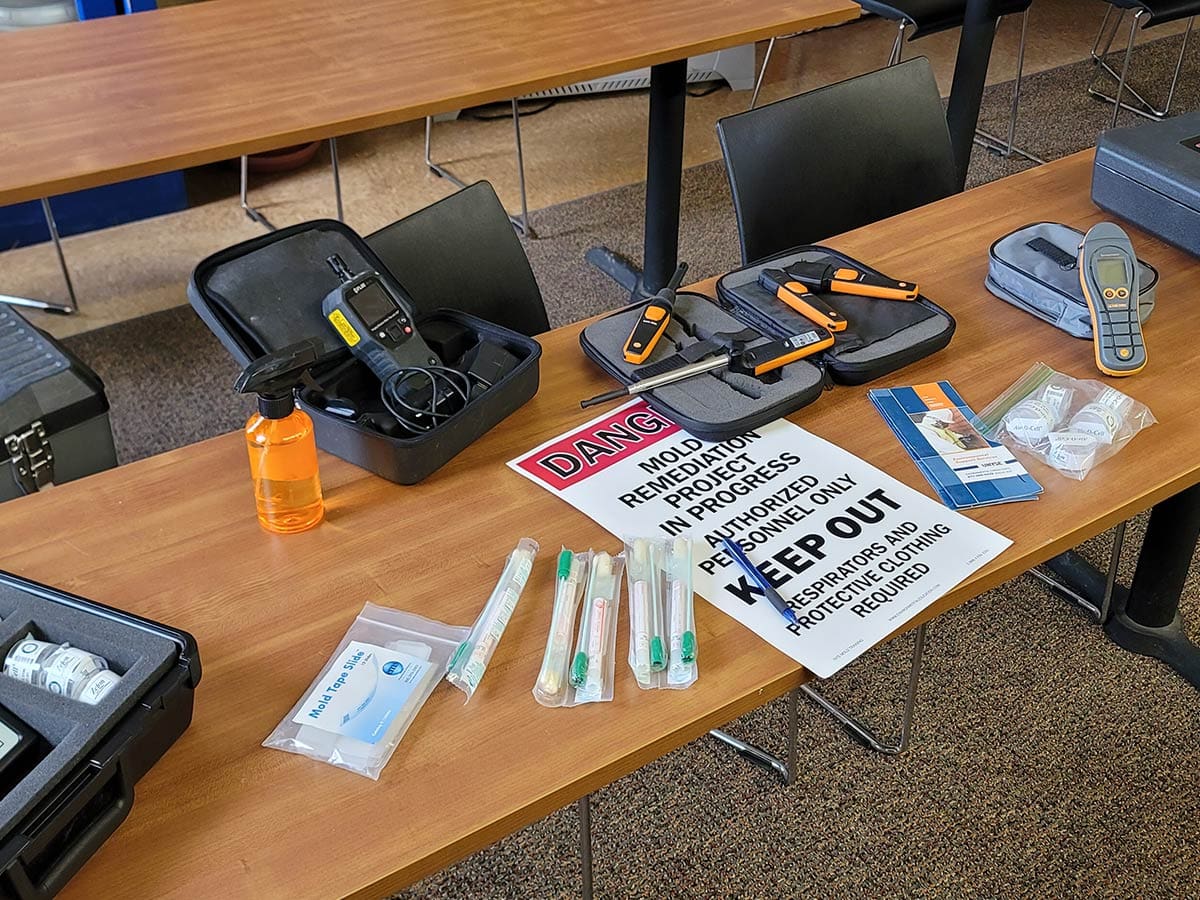 Mold remediation tools and safety sign on a table.