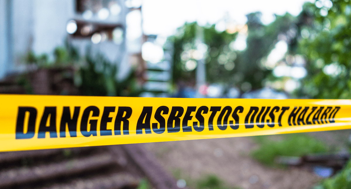 Yellow tape warning about asbestos dust hazard in construction area.